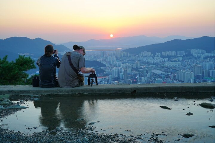 Witness the stunning night view of Busan from Hwangnyeongsan Mountain. Capture unforgettable moments against the backdrop of beautiful peaks and a city transformed by twilight. Enjoy local flavors after hiking.
